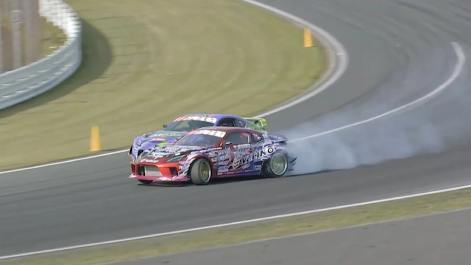 Drift car mid-corner with full smoke commitment at Suzuka Twin Circuit